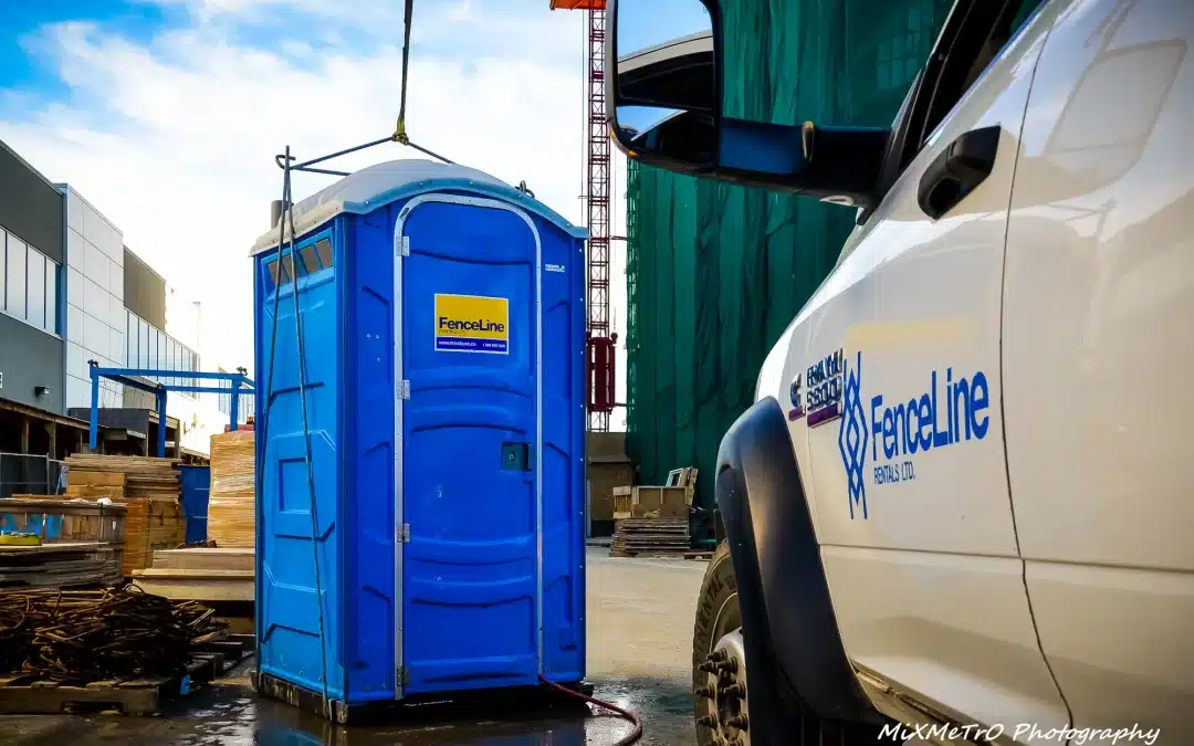 A portable toilet is lowered onto a site in Alberta by a crane.