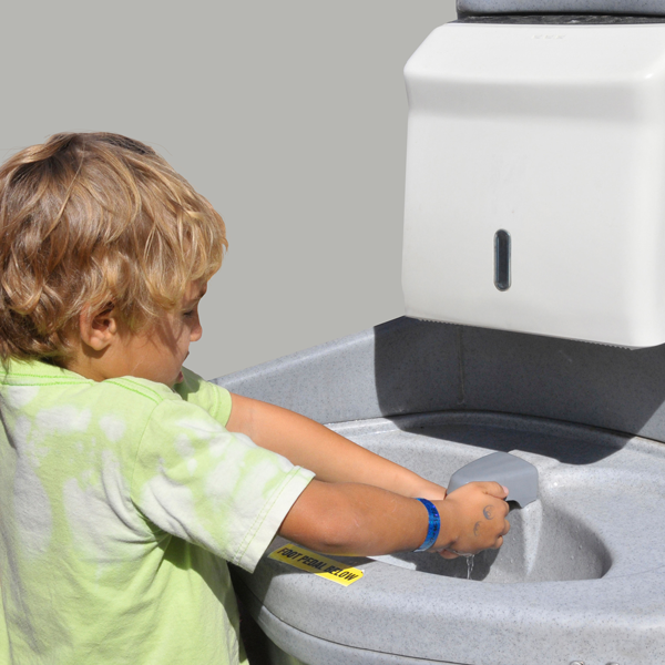 A child washing his hands at a portable hand wash station