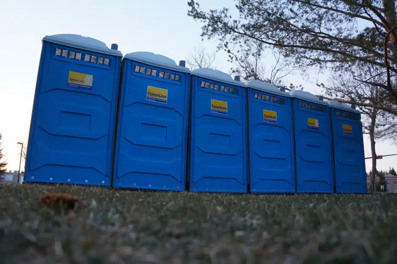 A row of portable toilets at an outdoor event.