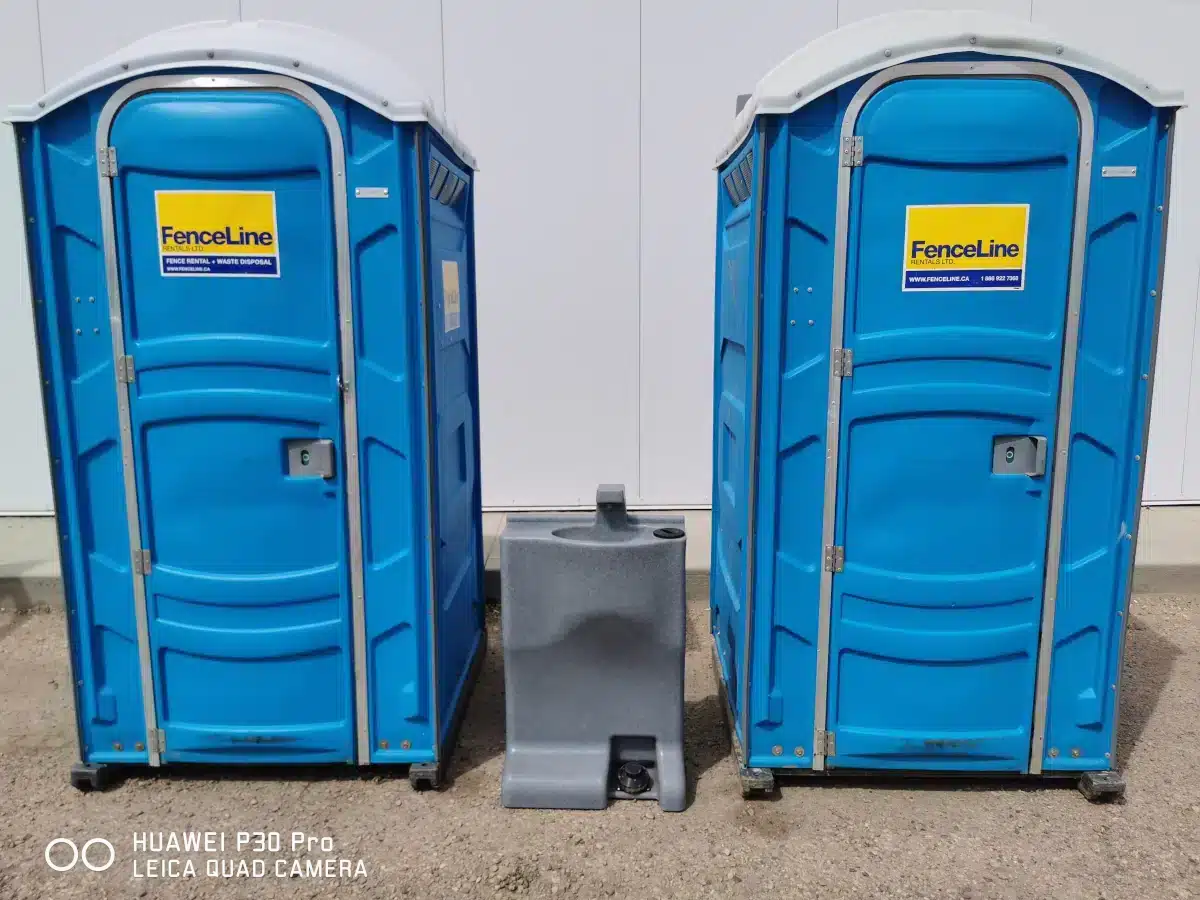 A hand cleaning station between two portable toilets