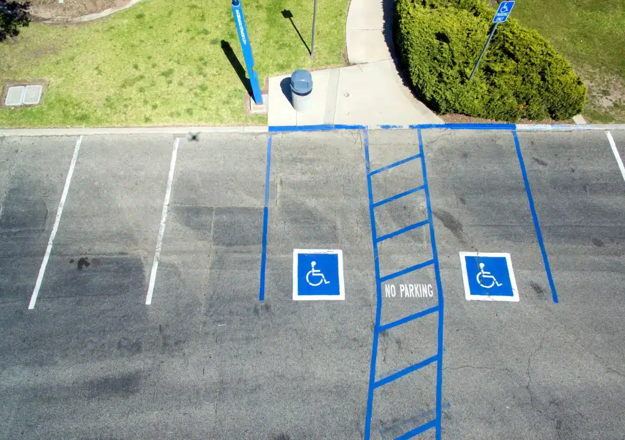 Two accessible parking stalls are clearly outlined in blue at a parking lot of an event in Calgary.