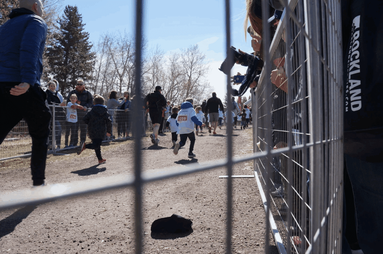 Kids run inside a temporary fence during a race event