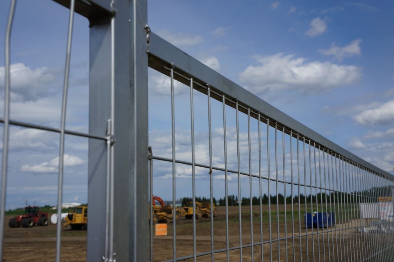 Close-up of a heavy-duty construction fence surrounding a large site.