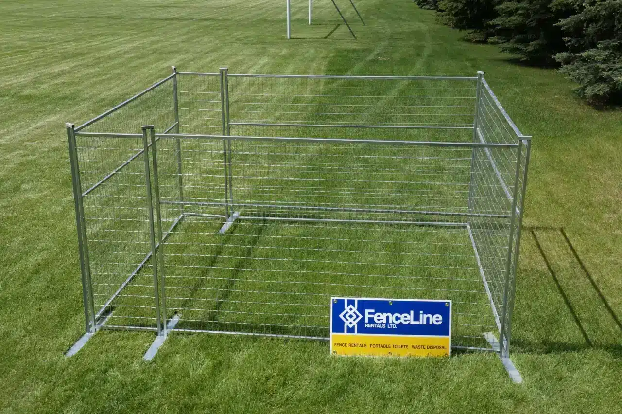 A small temporary dog run set up in a grassy field.