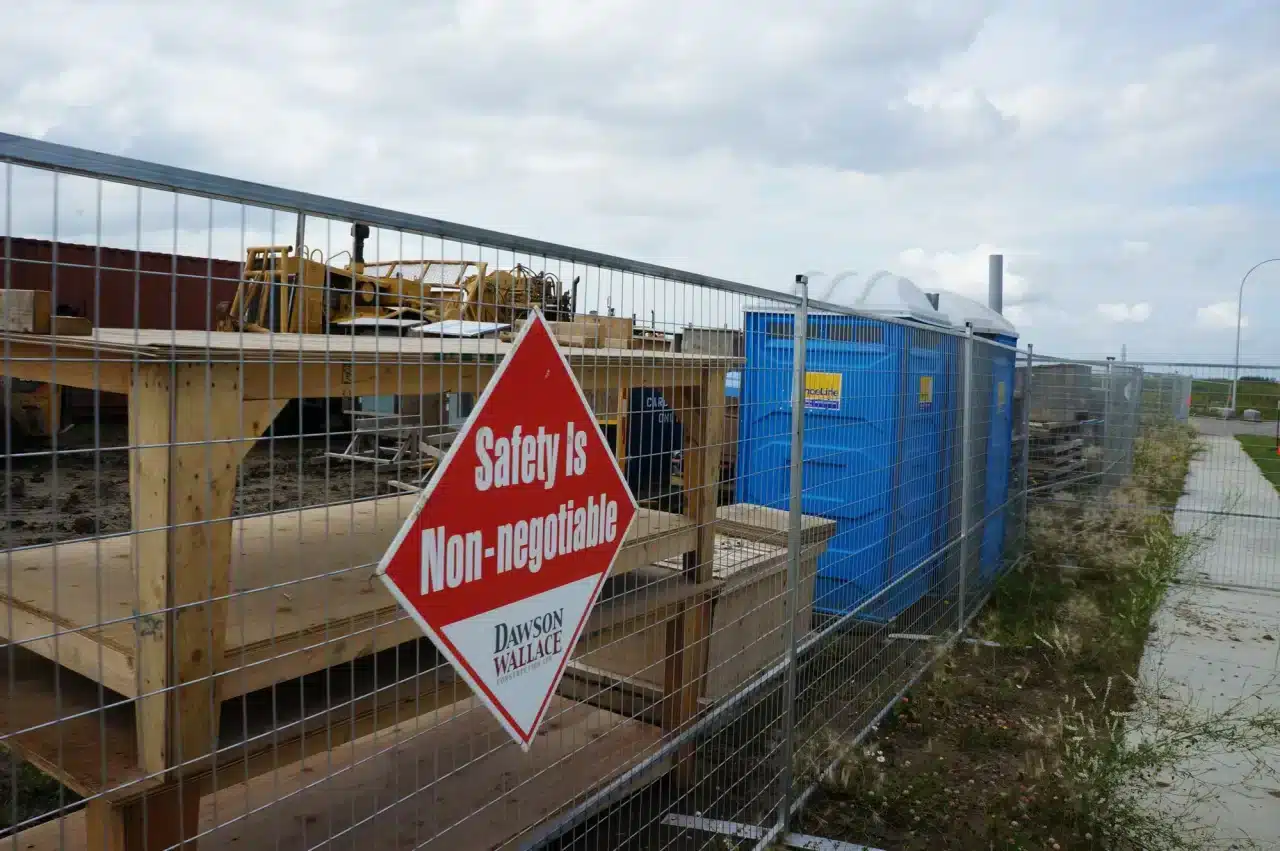 Portable toilets and temporary fencing on a job site near Calgary.