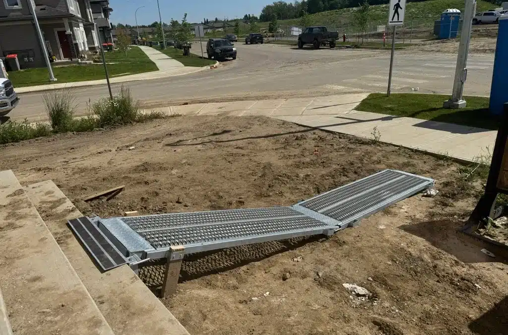 A temporary walkway provides a safe passage over dirt, connecting the sidewalk with stairs.
