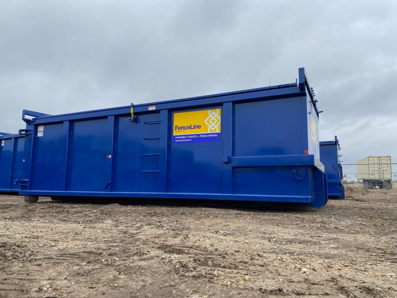 A large blue waste bin on a construction site in Alberta