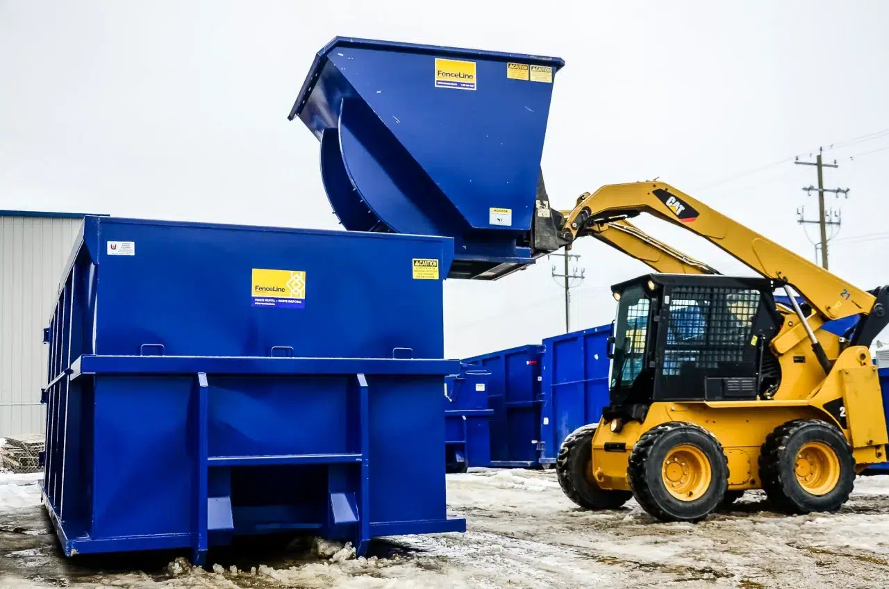 A small waste bin being bumped into a bigger waste bin on a construction site in Calgary